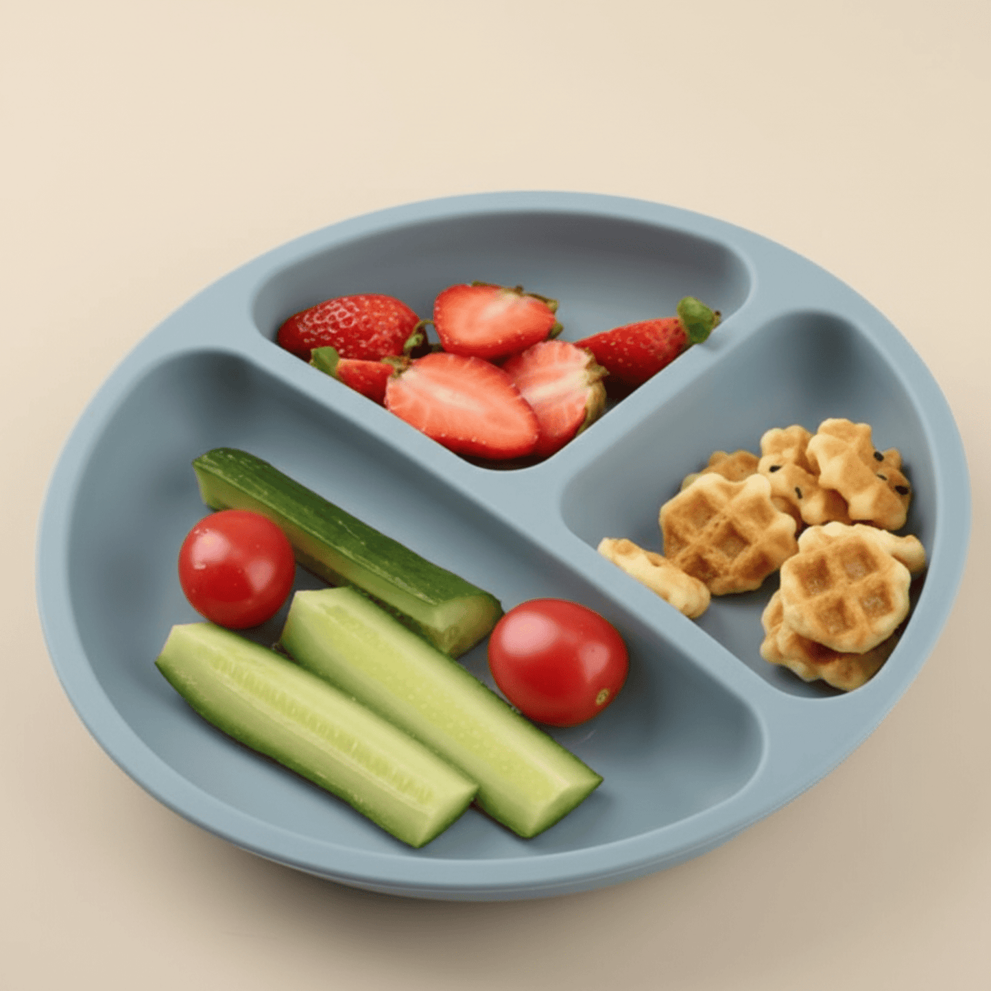 assiette bebe silicone à 3 compartiments coloris bleu gris contenant de la nourriture : crudités, fraises, mini-gaufres.