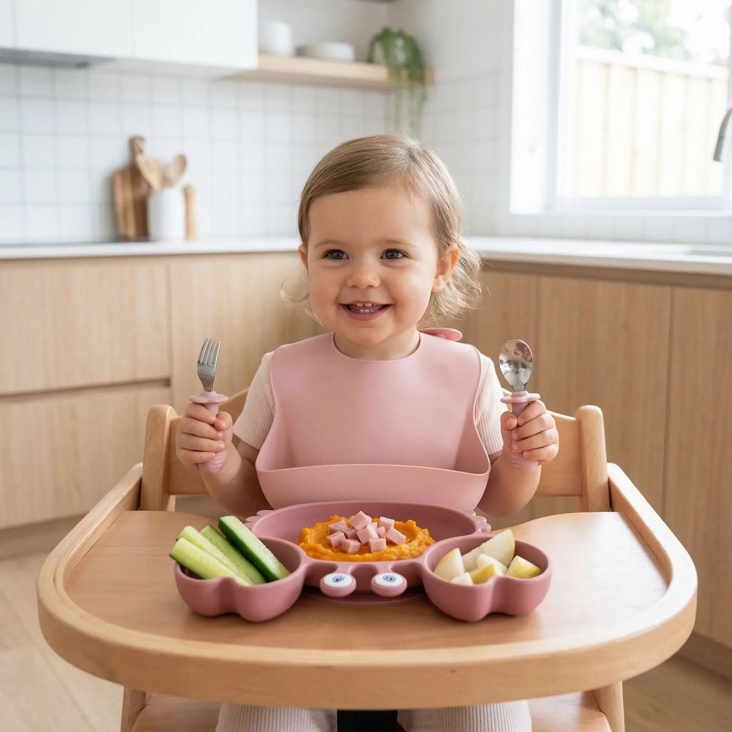 fillette devant son déjeuner complet dans l'assiette compartiment bébé rose en forme de crabe ventousée