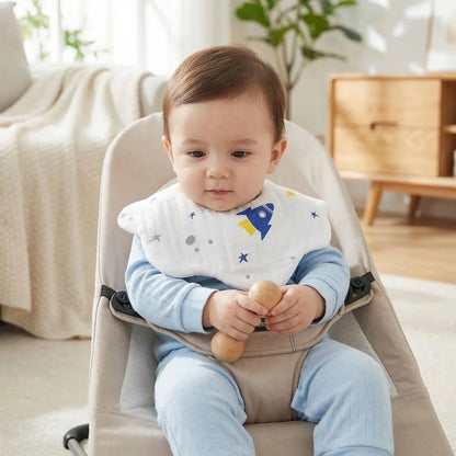 enfant qui joue avec un hochet dans son siège relax et porte le bavoir bebe en coton design fleur motif fusee