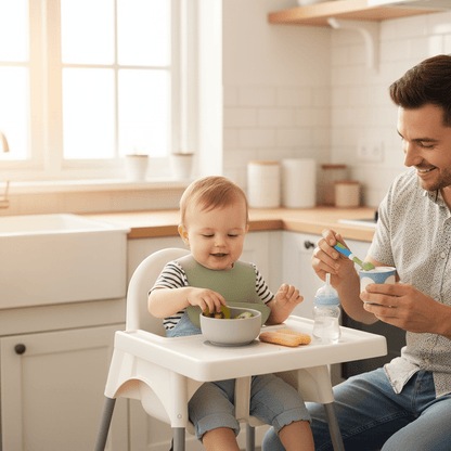 un enfant porte son bavoir bébé avec poche imperméable coloris vert sauge pour goûter avec son papa