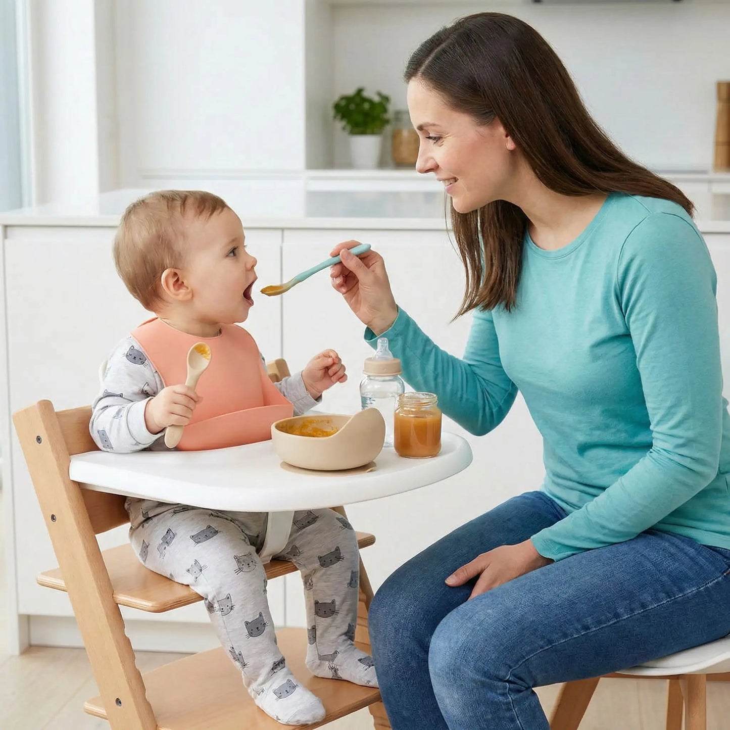 une maman donne un petit déjeuner fruité à son enfant qui porte le bavoir bébé avec poche imperméable coloris saumon