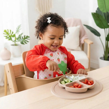 fillette déjeunant en autonomie avec le bavoir bébé manche longue étanche rouge motif fraise