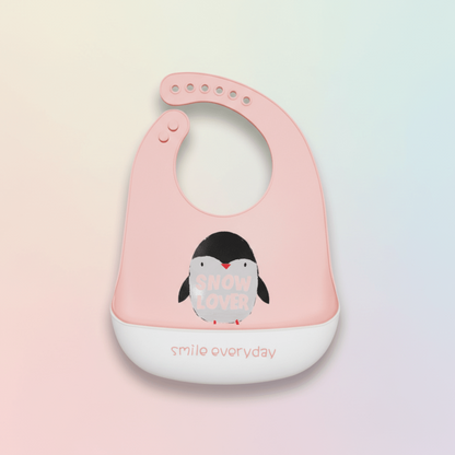 bavoir impermeable silicone rose motif pingouin avec anotation smile everyday sur le revers de la poche récupératrice