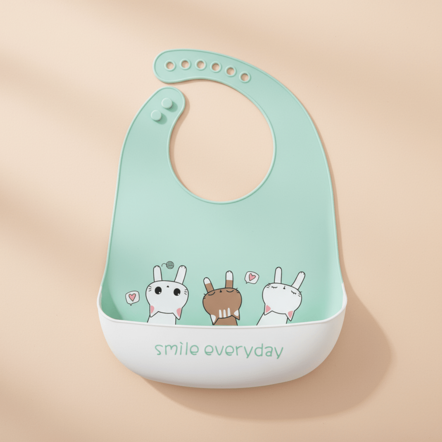 bavoir impermeable silicone vert motif chatons avec anotation smile everyday sur le revers de la poche récupératrice