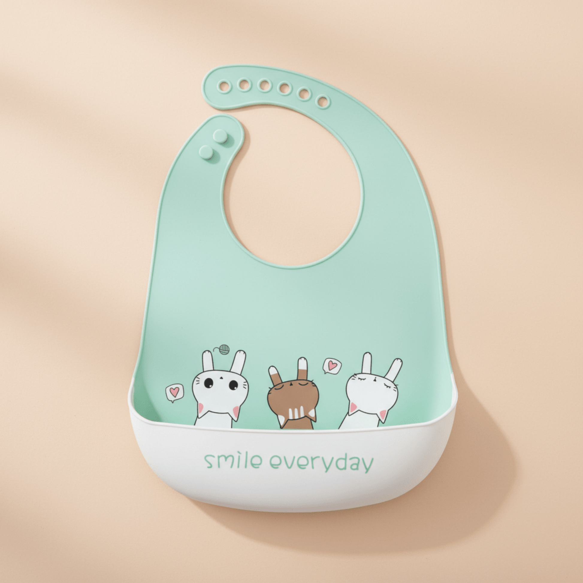 bavoir impermeable silicone vert motif chatons avec anotation smile everyday sur le revers de la poche récupératrice