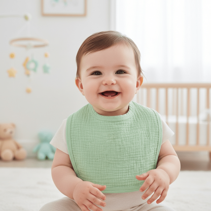 un bébé souriant dans sa chambre porte le bavoir en coton absorbant vert menhe