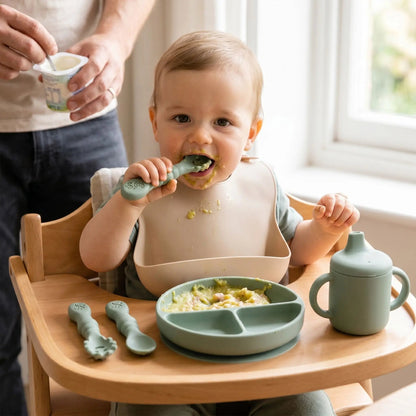 une fillette déguste sa purée de choux fleur avec sa cuillere ergonomique bebe à dents coloris vert.