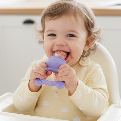 enfant dégustant du melon dans sa grignoteuse bebe ourson mauve