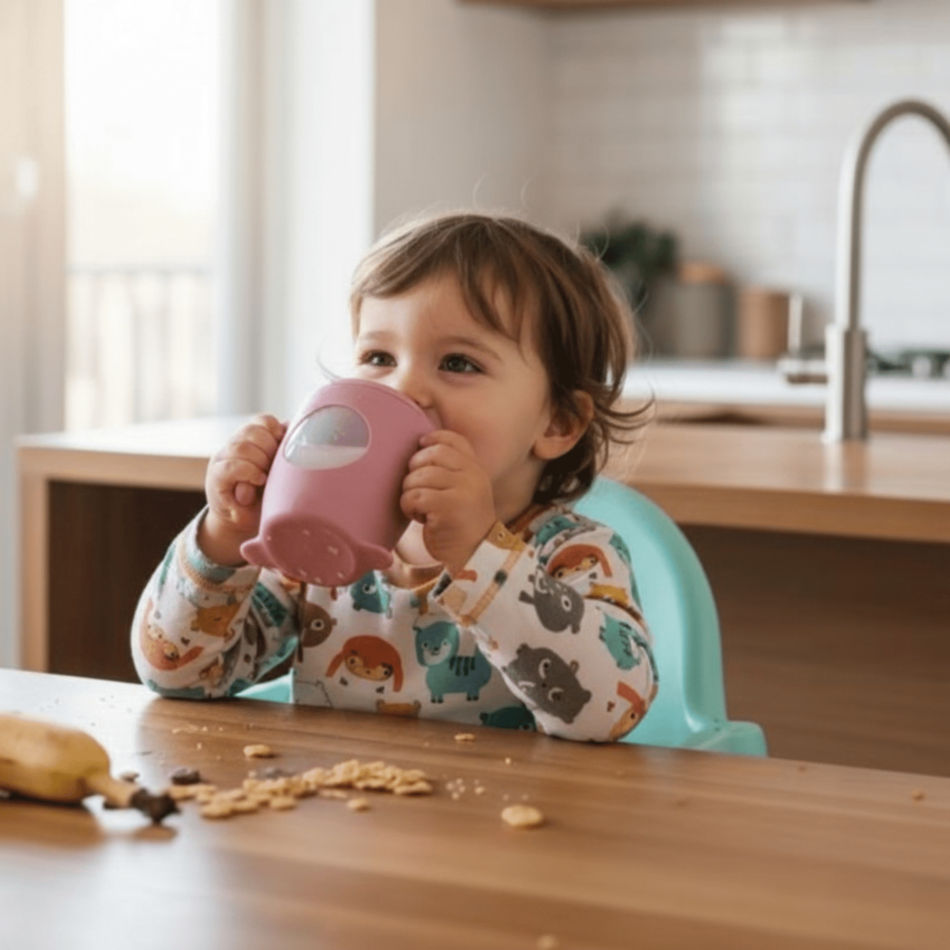 enfant à table utilisant la tasse d'apprentissage bebe coloris rose foncé 